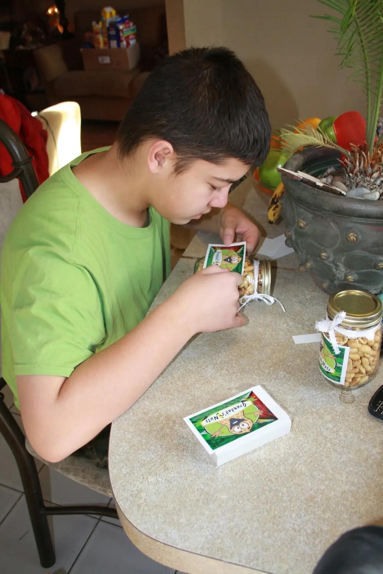 Braedon labelling early jars of Grandad's Nuts at the kitchen table