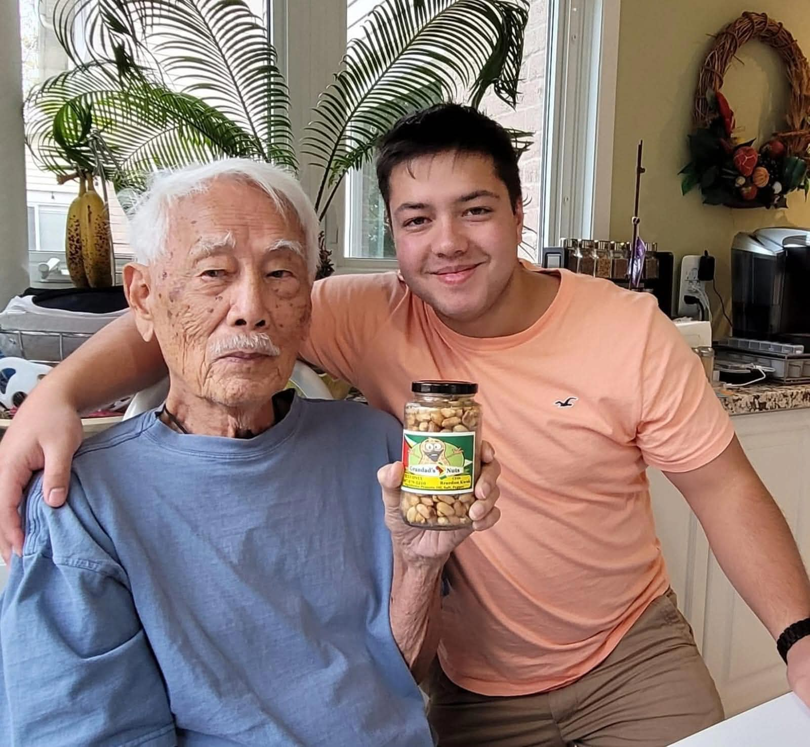 Braedon with Grandad Kwok holding a jar of peanuts