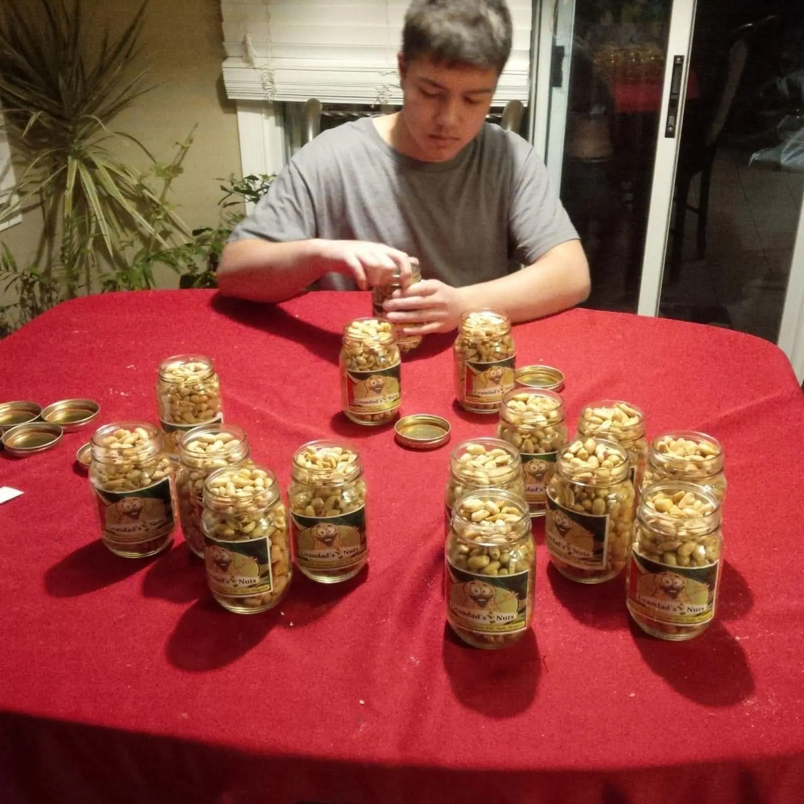 Braedon filling jars of peanuts at home